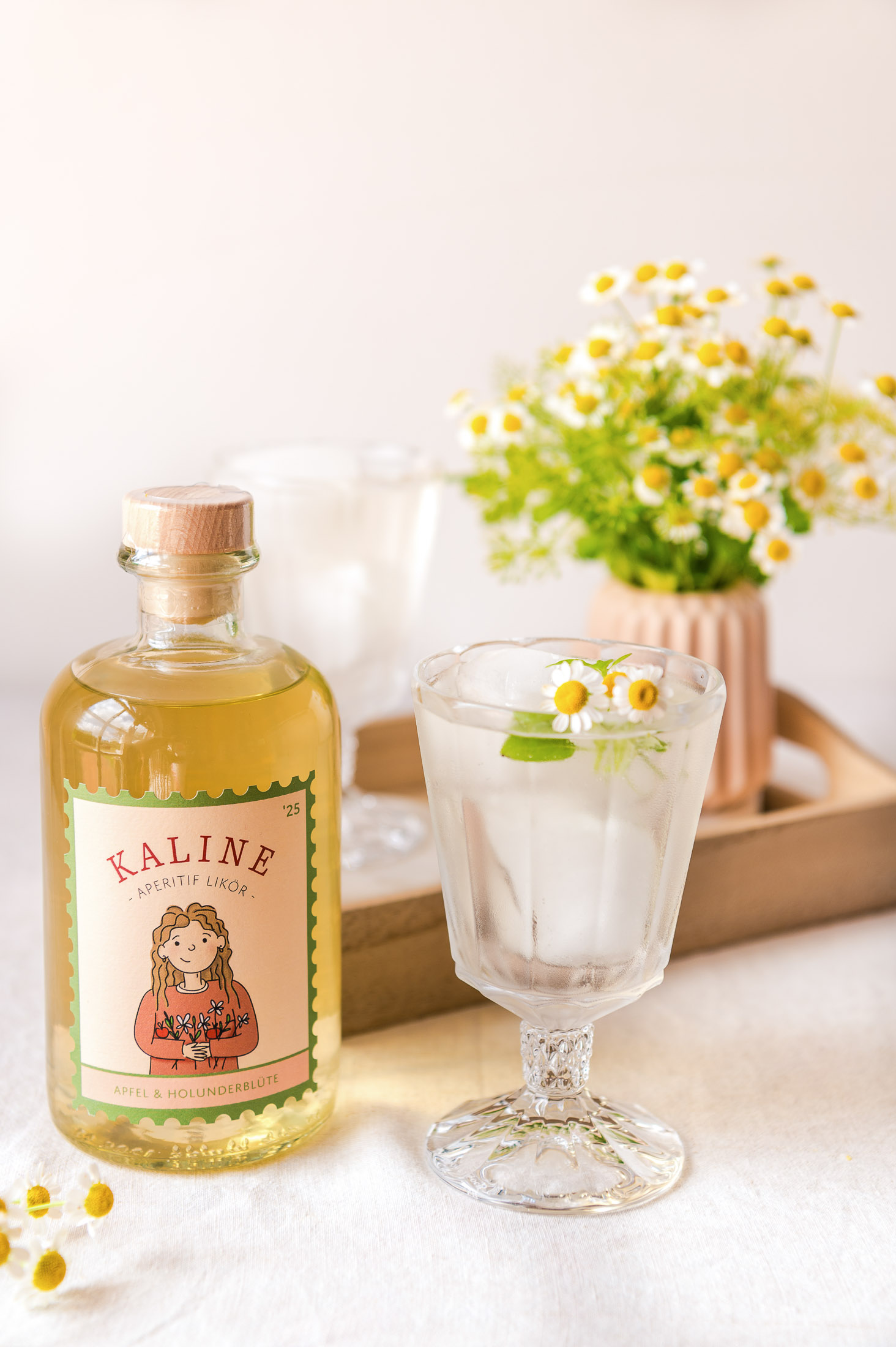 Kaline-Flasche neben einem hellen Drink mit kleinen weißen Blüten
